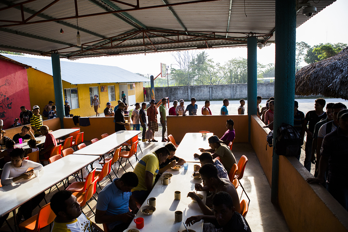 Men, women, and children journeying through Mexico are shown at the Los 72 shelter in Tenosique, Mexico, in April 2015. This shelter, run by Catholic priests and volunteers, provides mats to sleep on, second-hand clothes, meals, basic medical treatment, and help in applying for immigration visas and refugee status for men, women, and children traveling north. Photo by Katie Orlinsky.