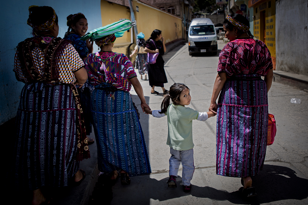 A four-year-old recent deportee stands outside her home in Quetzaltenango, Guatemala, with her aunts in August 2014. Along with her mother, she attempted to migrate to the United States on August 7, 2014, but was apprehended in Tuxtla Gutierrez, Mexico. Family members said they were both imprisoned and abused before being deported back to Guatemala. The girl’s mother continues to be unable to eat or speak after the experience. Photo by Katie Orlinsky.